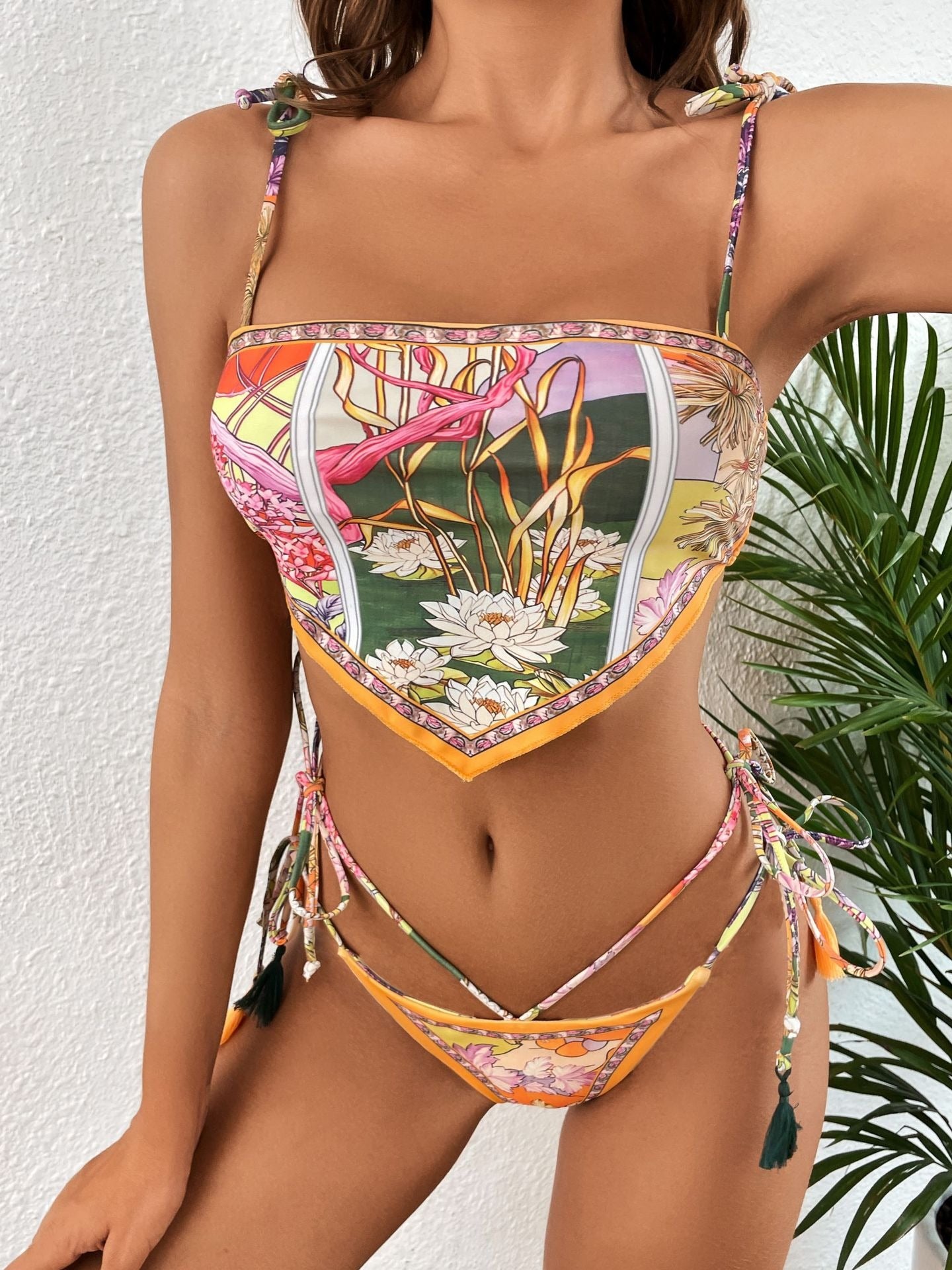 Woman wearing a colorful floral bikini against a white background