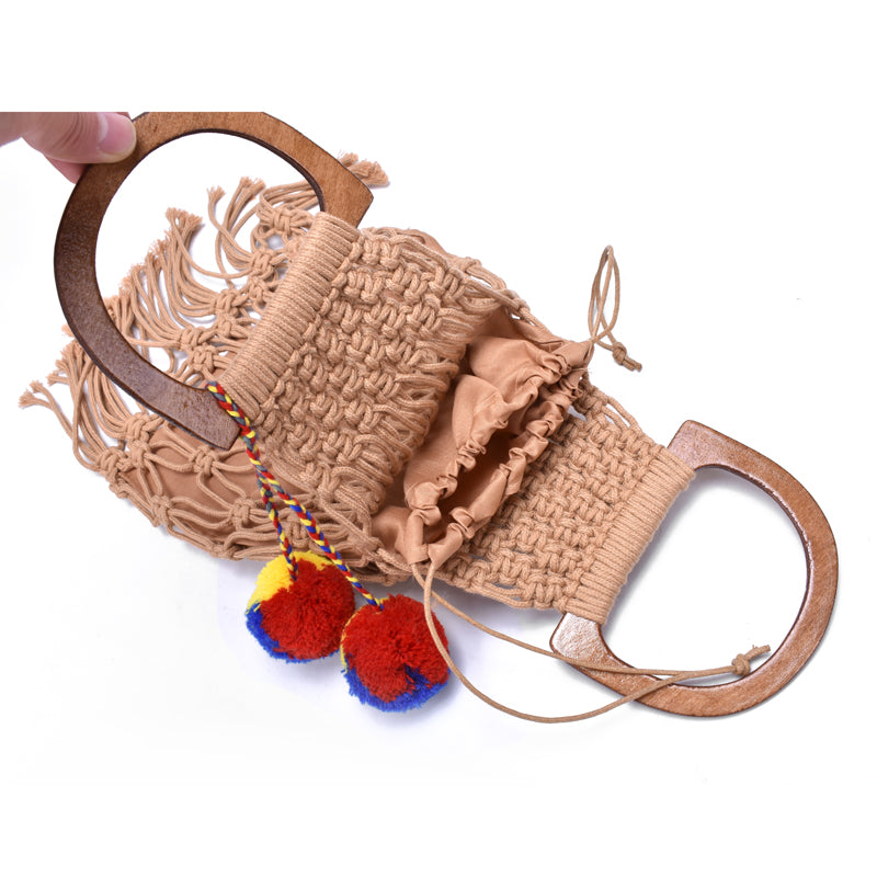 The inside of a brown woven handbag with wooden handles.