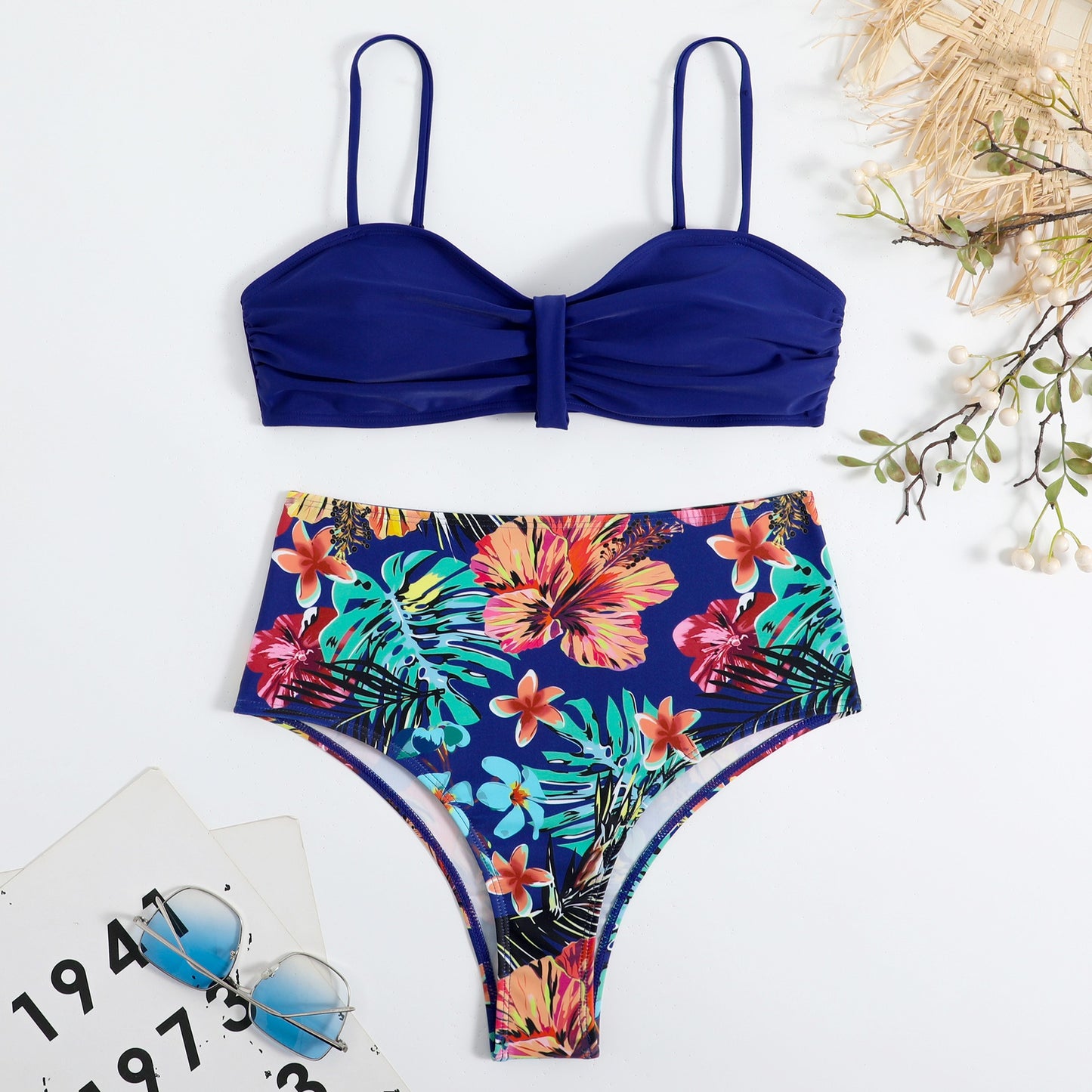 This two‑piece high‑waist bikini features a fragmented floral pattern blending bright color with a flattering, modern silhouette. 