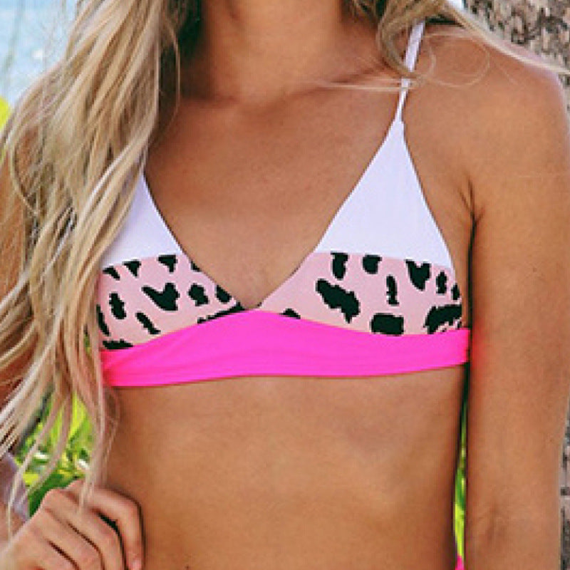 Woman wearing a pink and white bikini with leopard print details, posing against a plain background.