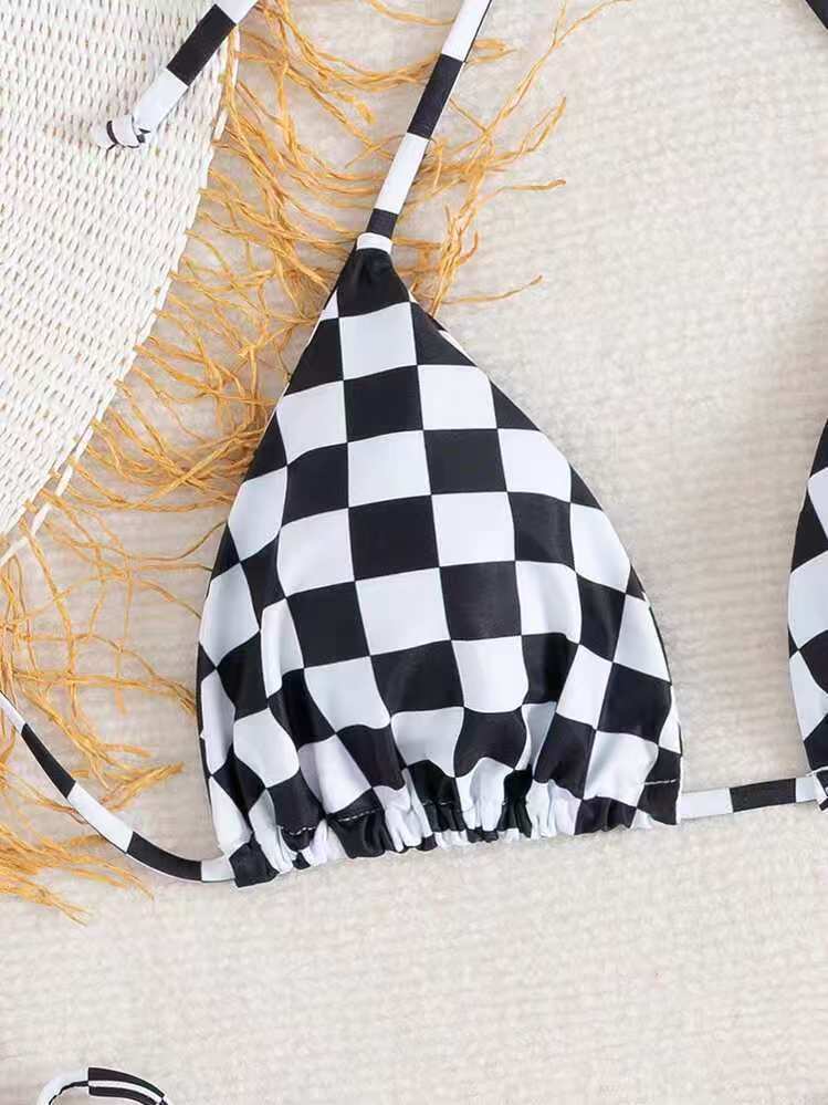 Black and white checkered bikini top on a textured surface