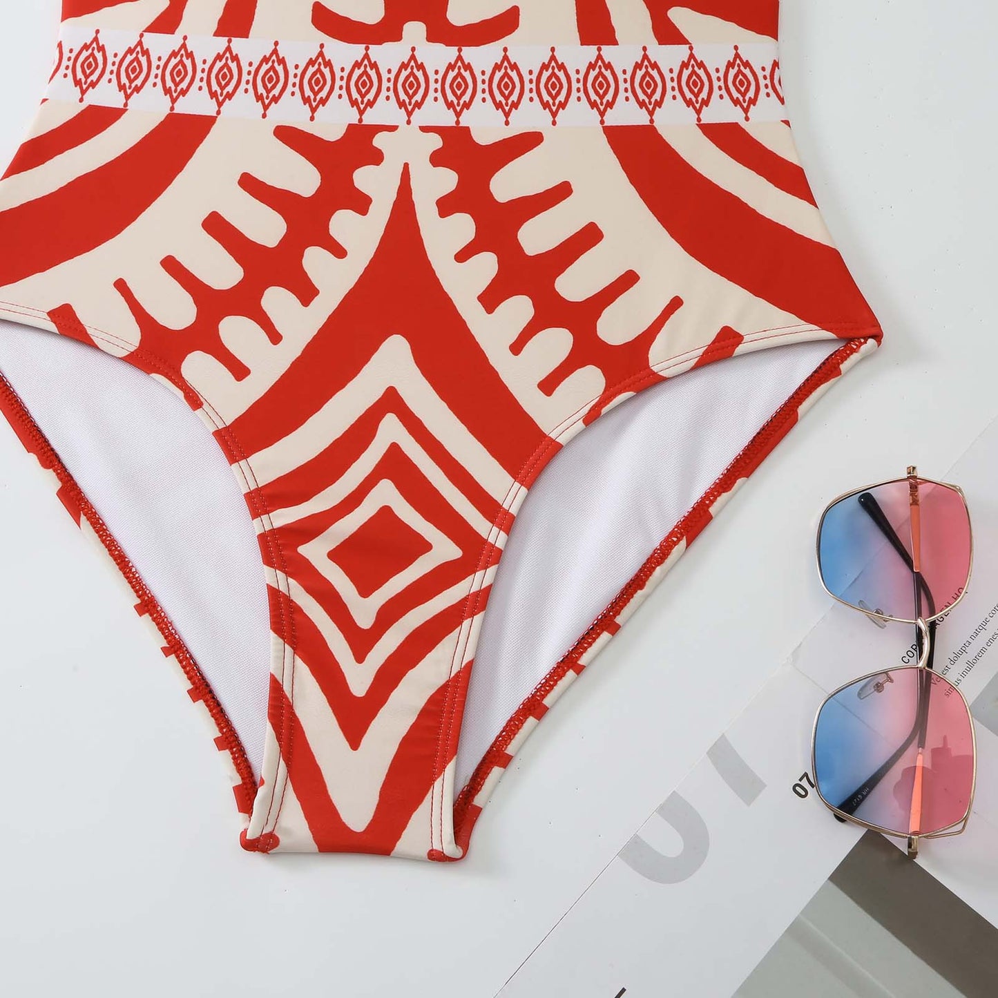 Red and white patterned bikini bottom with sunglasses on a magazine