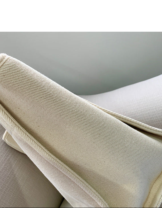 Close-up of a textured fabric with 'Beau' embroidery and a folded beige fabric.