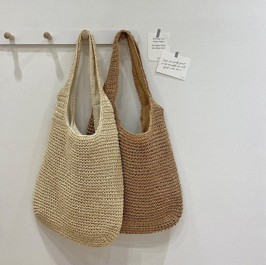 Two woven bags hanging on a hook against a white wall. Sold at PeachyBeanz.