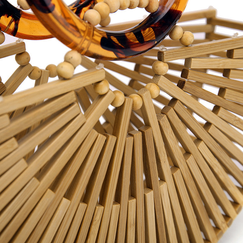 Close-up of a woven handbag with wooden beads and tortoiseshell accents sold at PeachyBeanz.