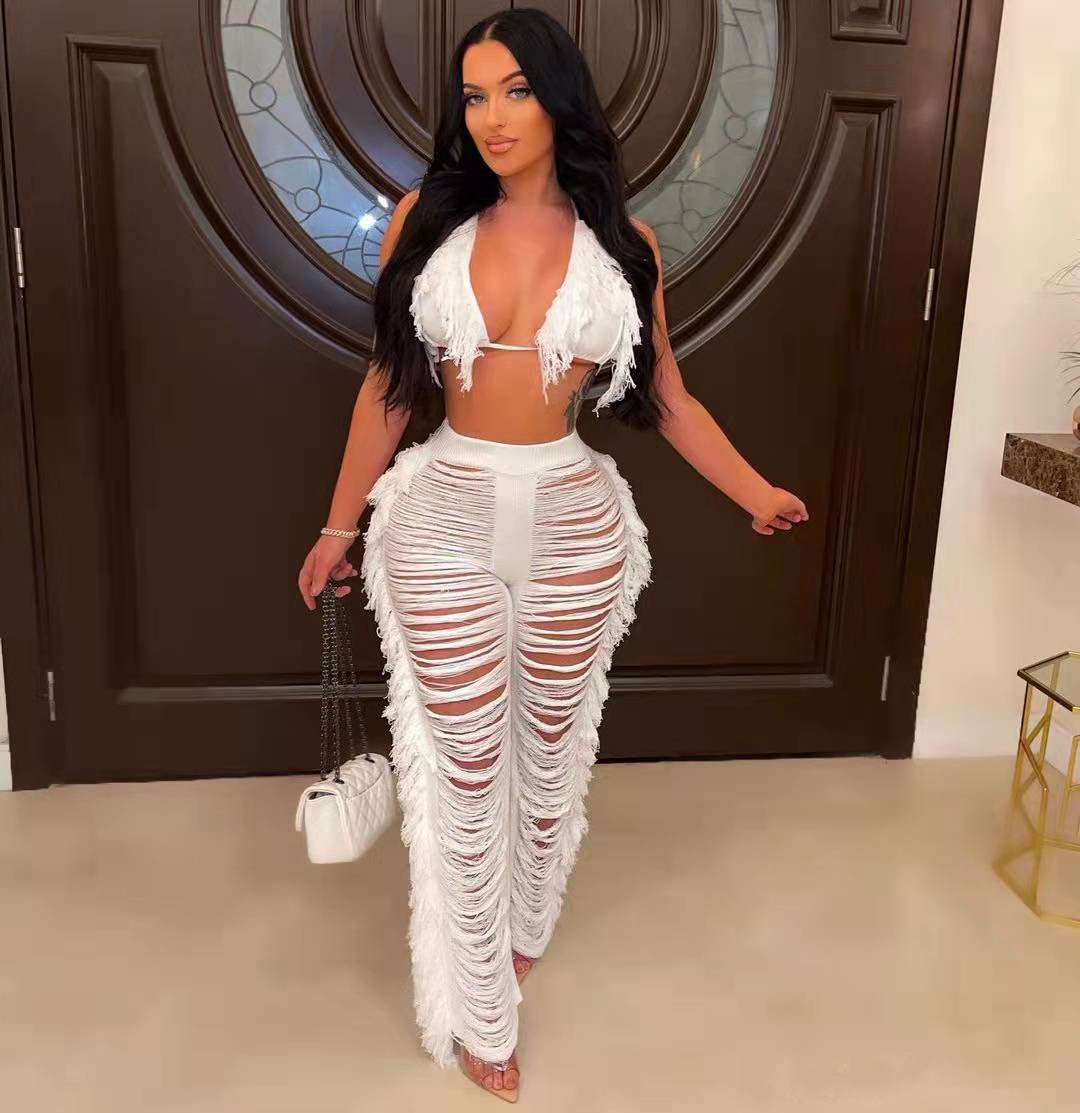 Woman in a white fringe outfit standing in a room with a decorative door.