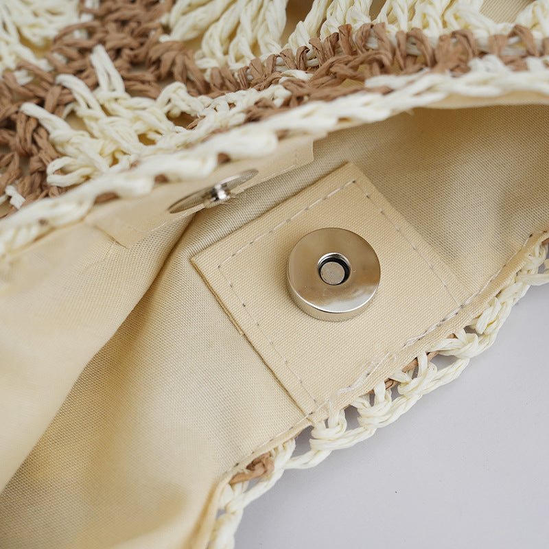 Close-up of a beige fabric with a metal button and crochet details on a light gray background