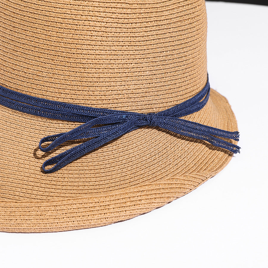 Close-up of a straw hat with a blue band on a white background