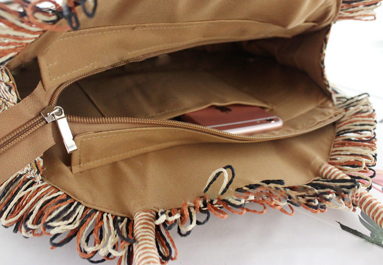 Brown bag with fringes and a phone inside on a white background