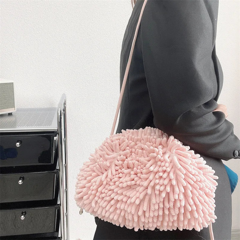 Person holding a pink textured handbag against a white wall sold at PeachyBeanz.