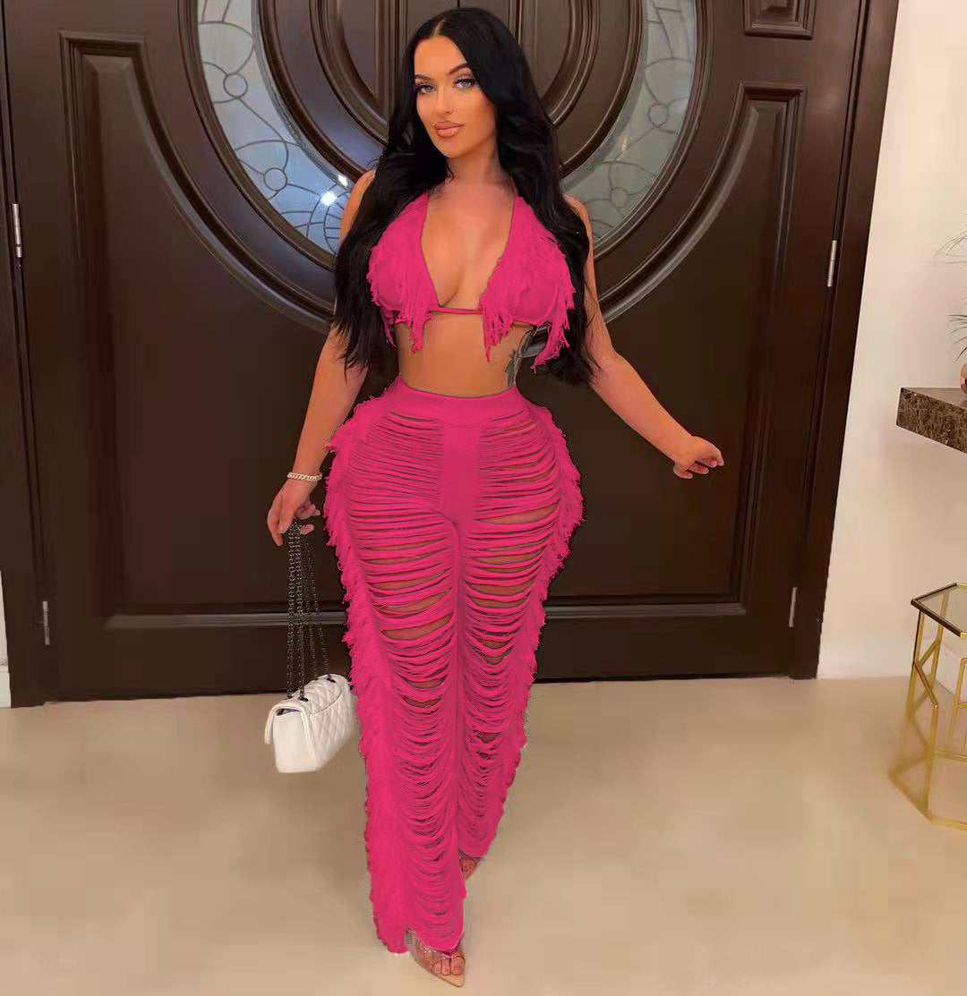 Woman in a bright pink outfit standing in a room with a decorative door.