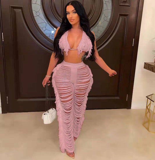 Woman in a pink outfit standing in a room with a decorative door.