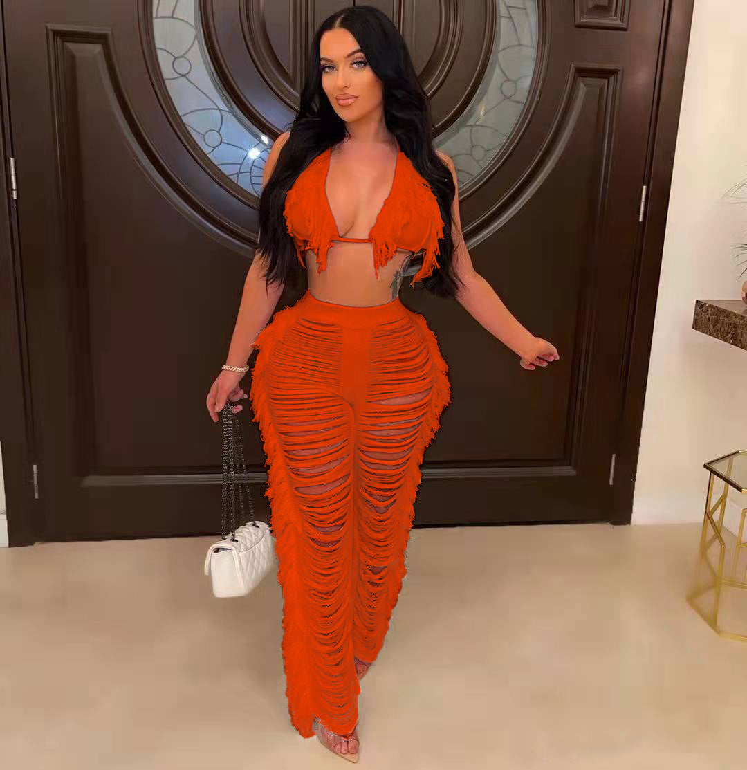 Woman in an orange outfit standing in a room with a decorative door.