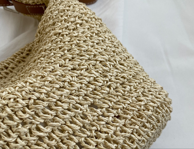 Close-up of a beige woven bag on a white background
