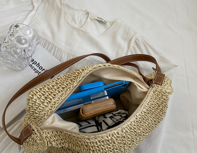 Woven handbag with items inside on a white surface