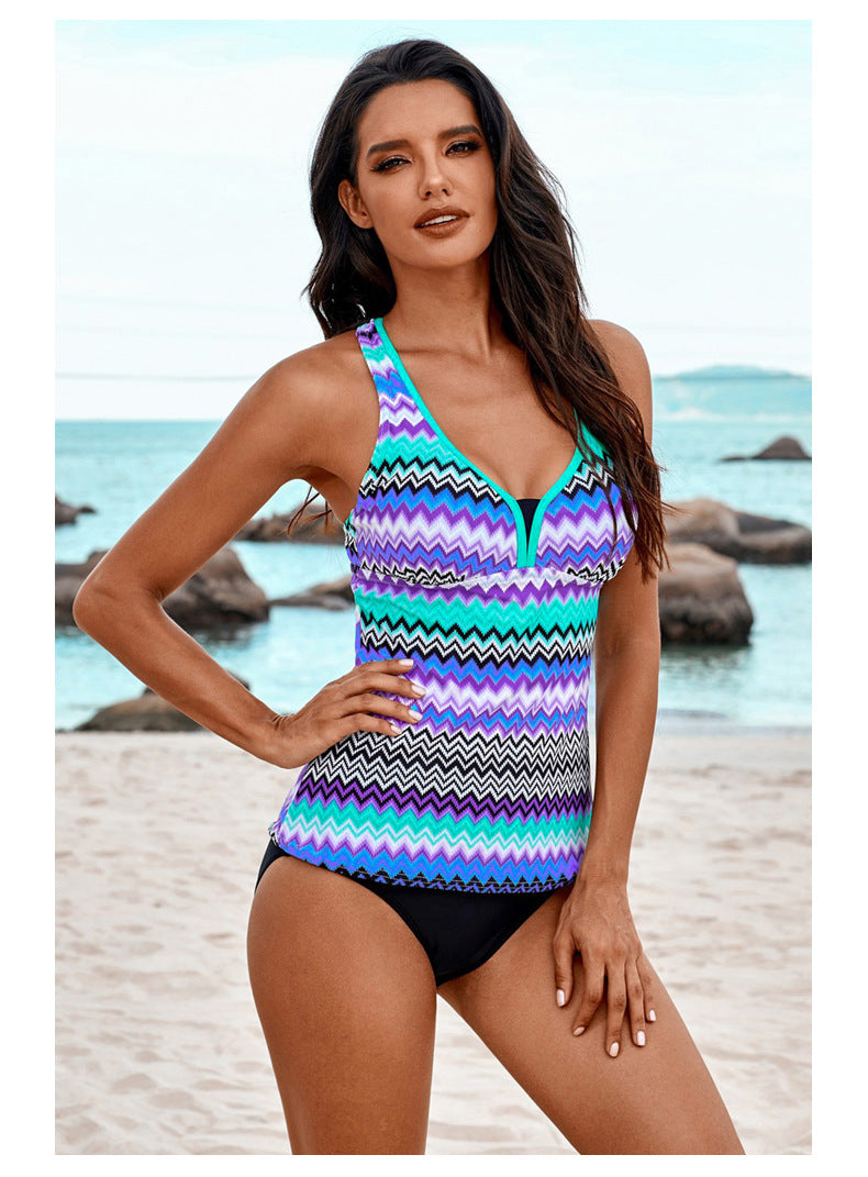 Woman wearing a colorful zigzag patterned swimsuit on a beach.