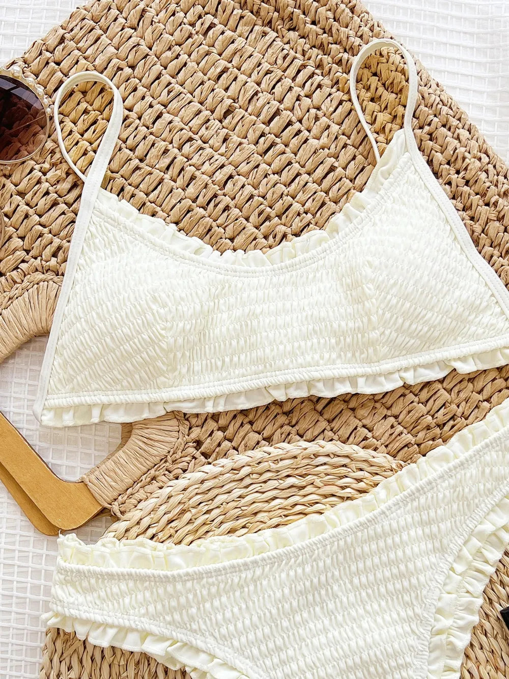 White scrunchy-patterned bikini with matching top and bottom, featuring spaghetti straps.