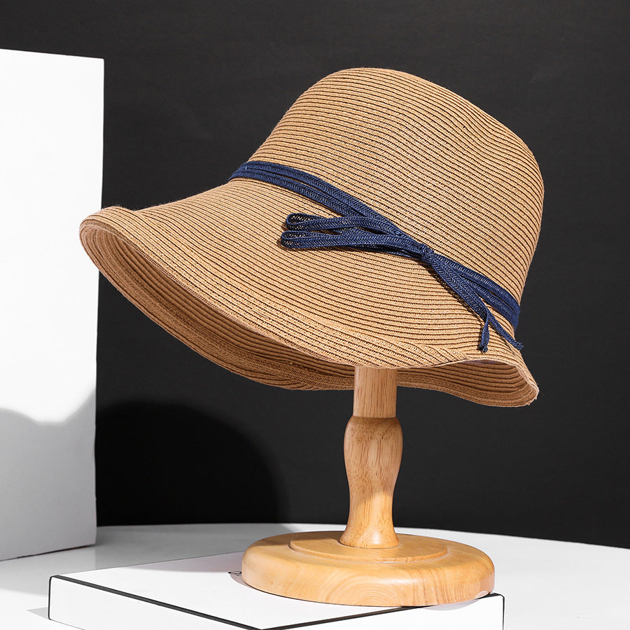 Close-up of a straw hat with a blue band on a white background