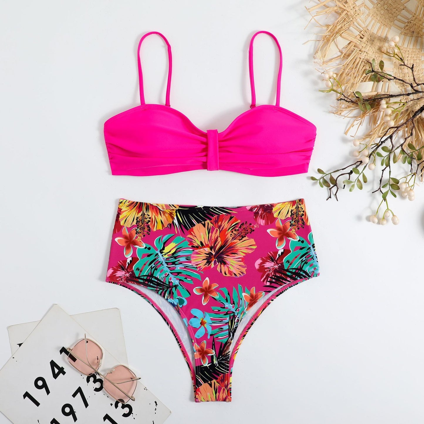 This two‑piece high‑waist bikini features a fragmented floral pattern blending bright color with a flattering, modern silhouette. 