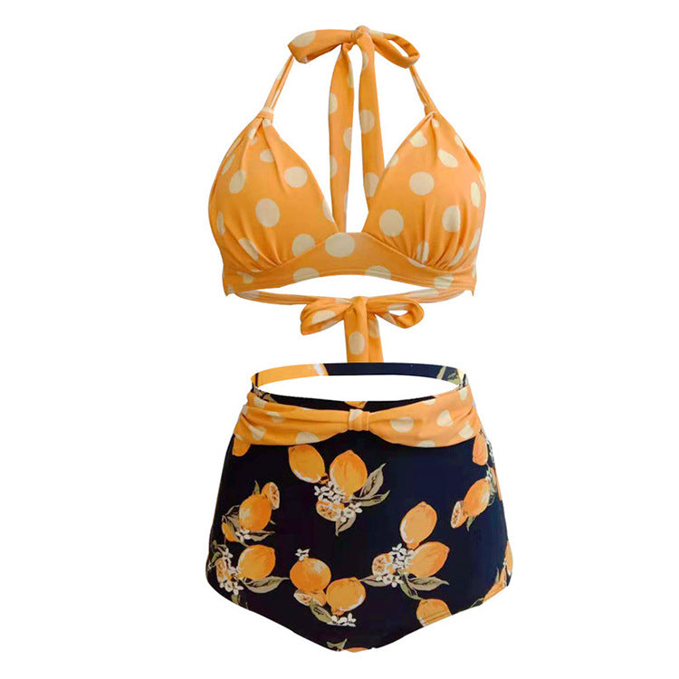 Woman wearing a yellow polka dot halter bikini top and high‑waisted blue lemon patterned  bottom.