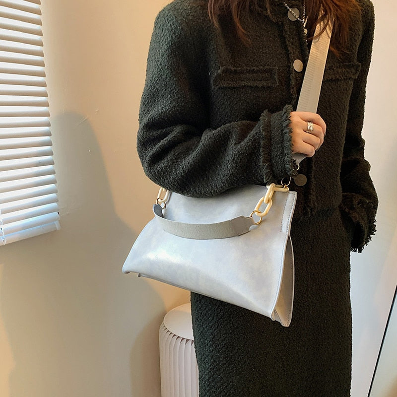 Large women's shoulder bag in soft faux leather, front view showing smooth finish and slim silhouette, black variant. Sold at PeachyBeanz.
