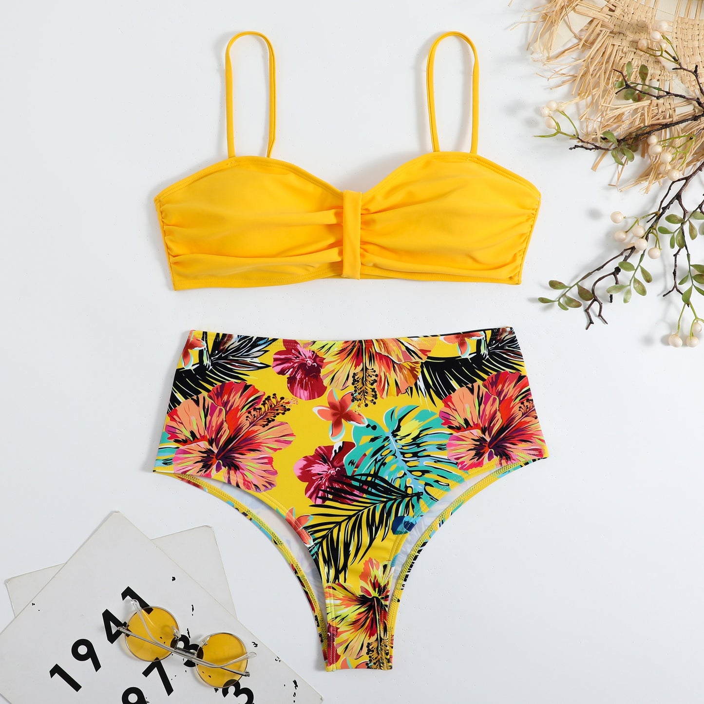 This two‑piece high‑waist bikini features a fragmented floral pattern blending bright color with a flattering, modern silhouette. 
