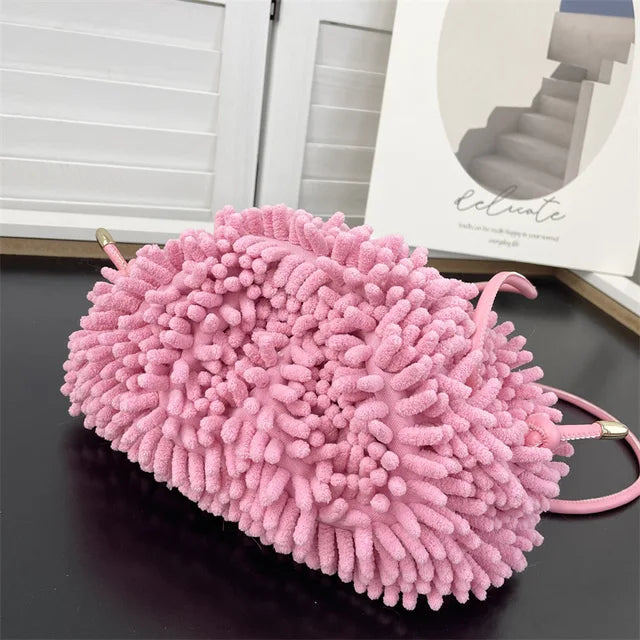 Person holding a pink textured handbag against a white wall sold at PeachyBeanz.
