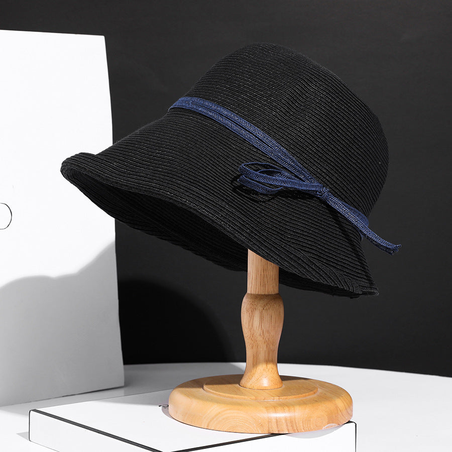 Close-up of a straw hat with a blue band on a white background