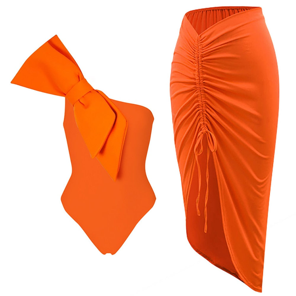 Orange bowknot shoulder‑strap one‑piece swimsuit with ruched bodice and matching lightweight beach cover‑up.