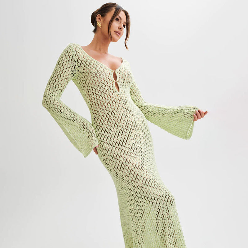Woman wearing a light green knitted dress with bell sleeves on a white background