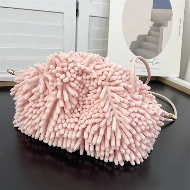 Person holding a pink textured handbag against a white wall sold at PeachyBeanz.