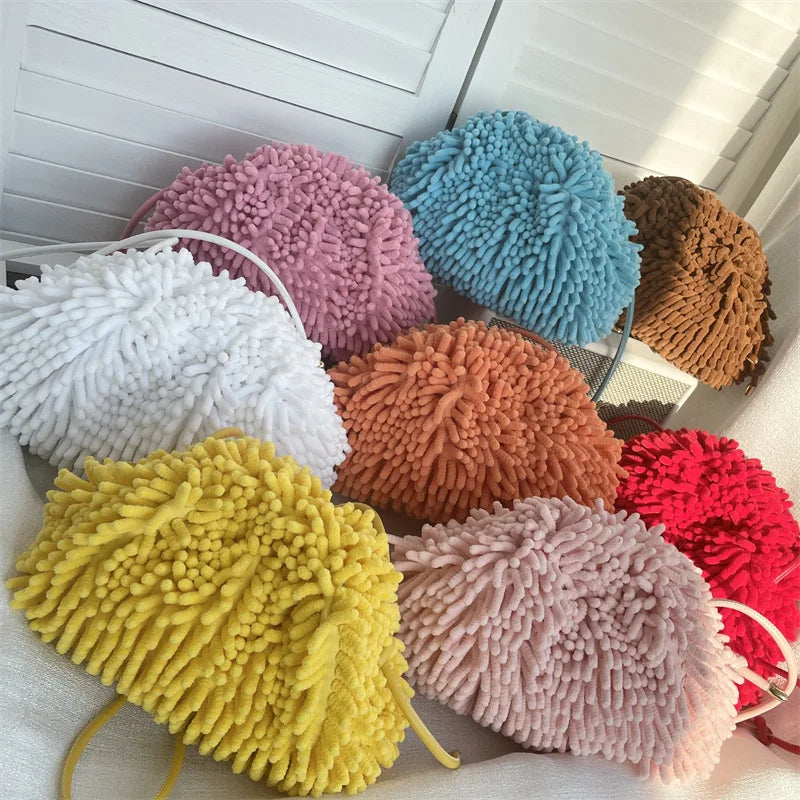 PomPom Pouch textured handbags against a white wall sold at PeachyBeanz. 
