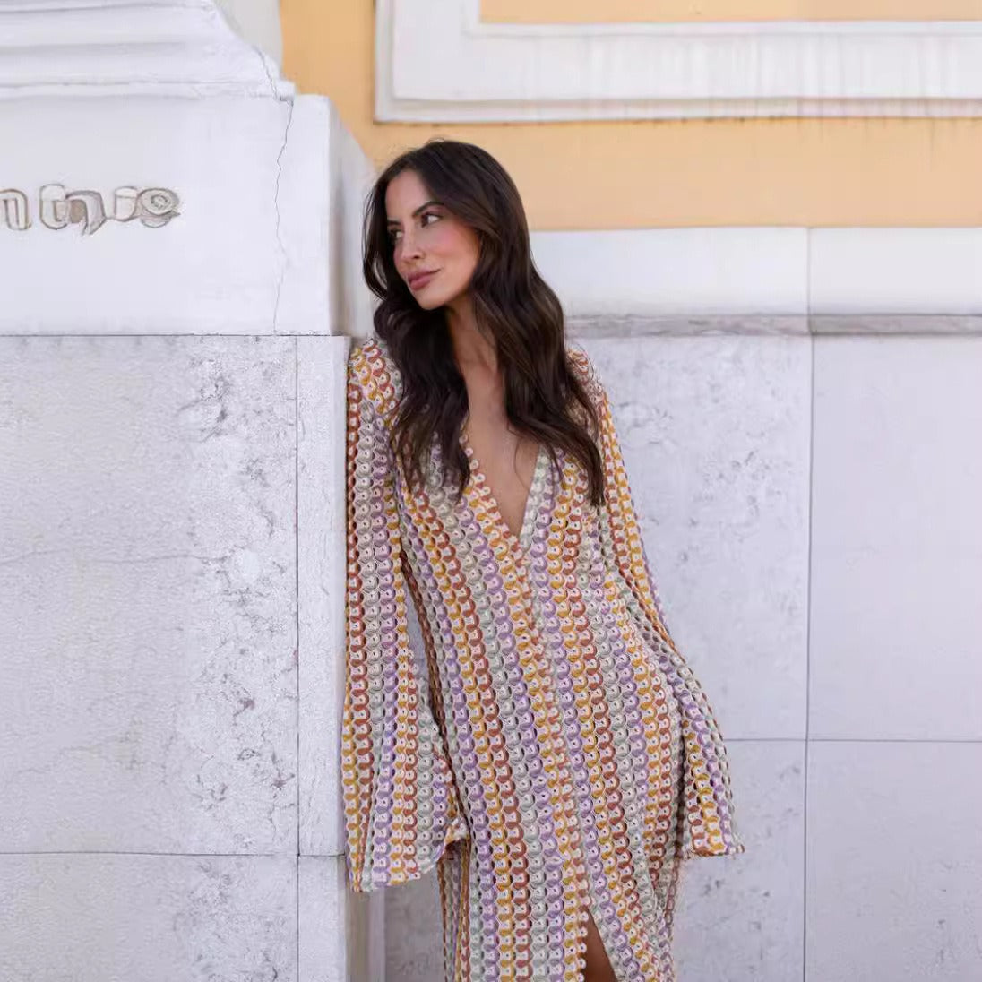Person standing in a colorful swimsuit dress cover-up with a patterned design.
