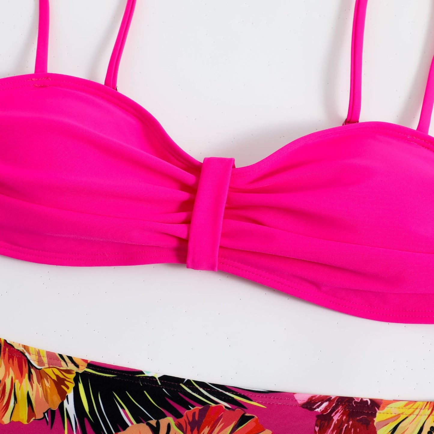 This two‑piece high‑waist bikini features a fragmented floral pattern blending bright color with a flattering, modern silhouette. 