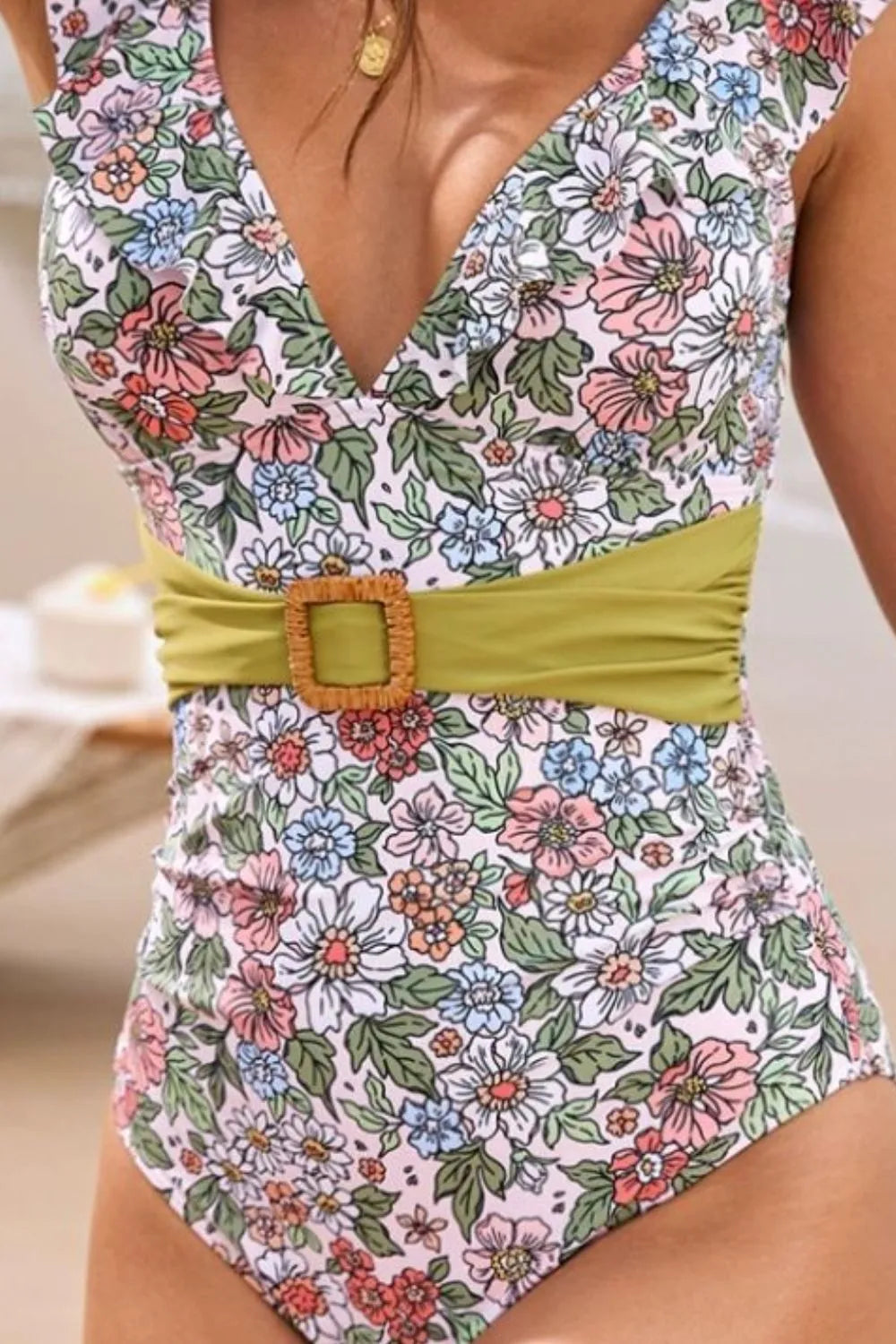 Ruffled plunge one‑piece swimsuit with belt.