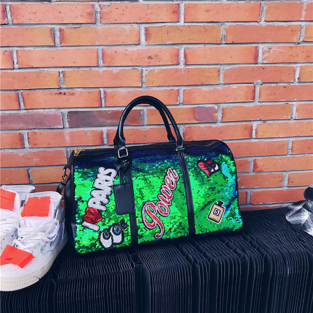 Green sequin clutch with 'I ❤️ Parks' text against a brick wall.