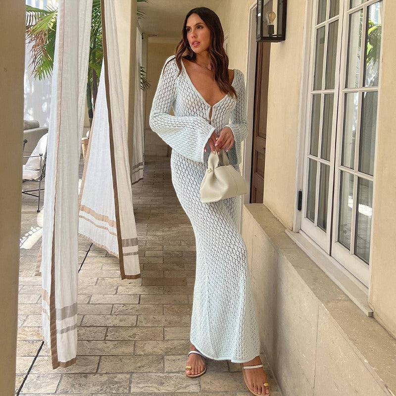 Woman in a white textured dress standing in front of a building entrance.