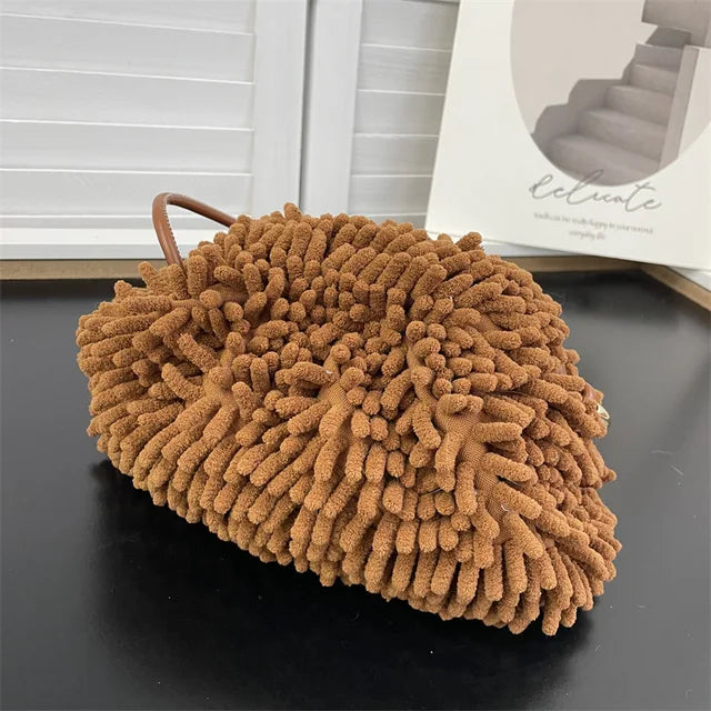 Person holding a brown textured handbag against a white wall sold at PeachyBeanz.