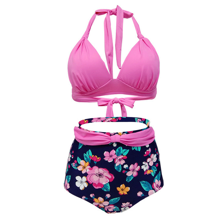 Woman wearing a pink halter bikini top and high‑waisted blue floral bottoms.
