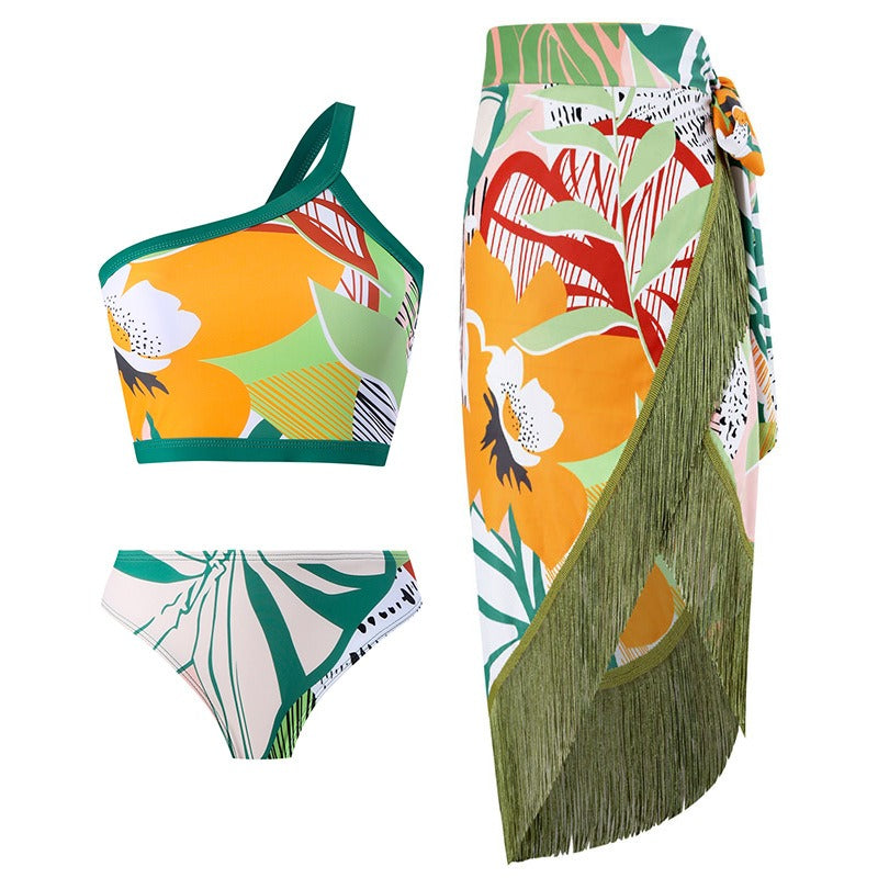 Tropical one‑shoulder bikini with wrap skirt; vibrant floral print, and adjustable strap.