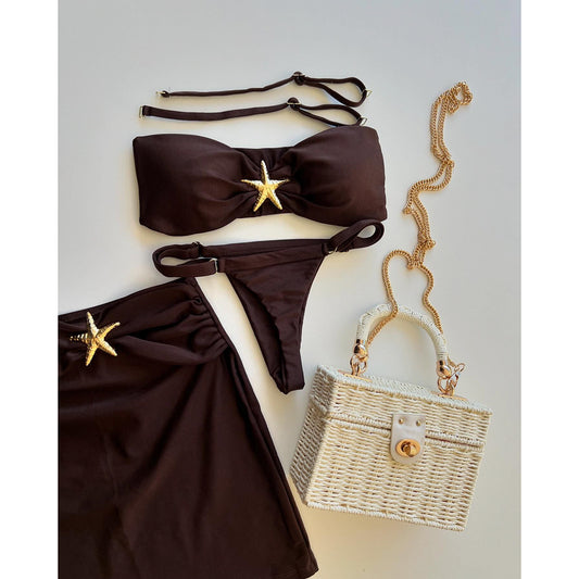 Brown bikini set with starfish decorations on a light gray 
