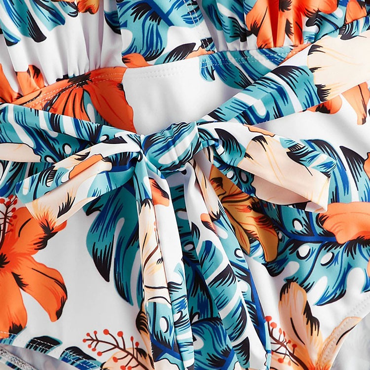 Backless short‑sleeve one‑piece swimsuit with fragmented flowers print; polyester shell 82% polyester fiber, 100% polyester lining, chest pad without steel support, quick‑drying, highly elastic, widened and thickened panels, ideal for fitness, cycling, and water sports.
