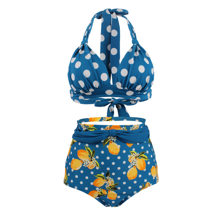 Woman wearing a blue polka dot halter bikini top and high‑waisted blue lemon patterned bottoms.