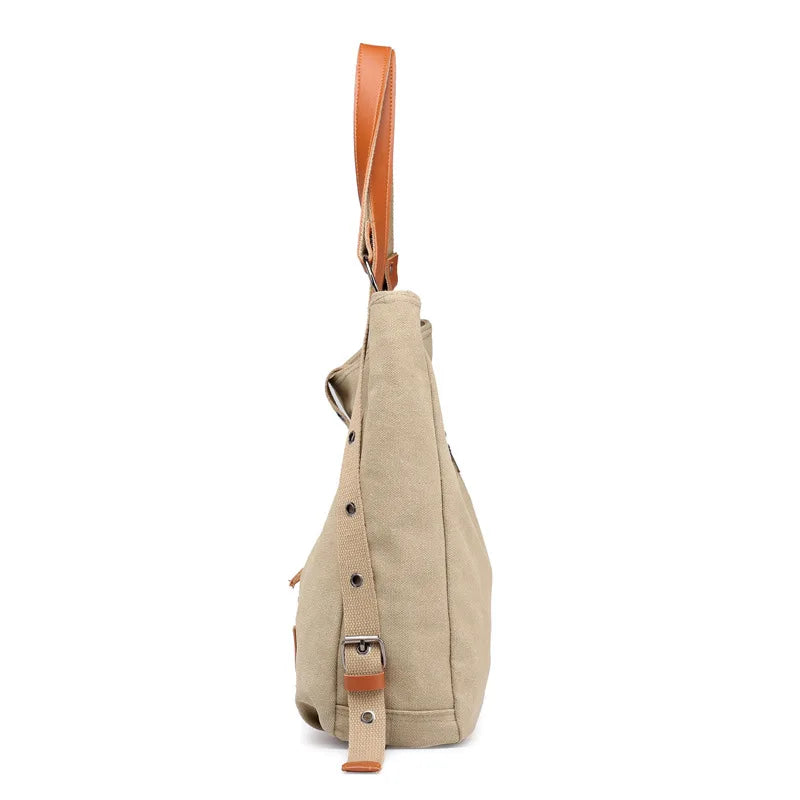 Women’s soft canvas backpack with zipper closure, top handle, and shoulder straps, featuring external pockets and a casual everyday design.