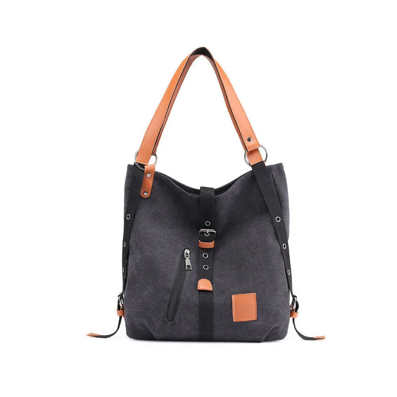 Women’s soft canvas backpack in black with zipper closure, top handle, and shoulder straps, featuring external pockets and a casual everyday design.