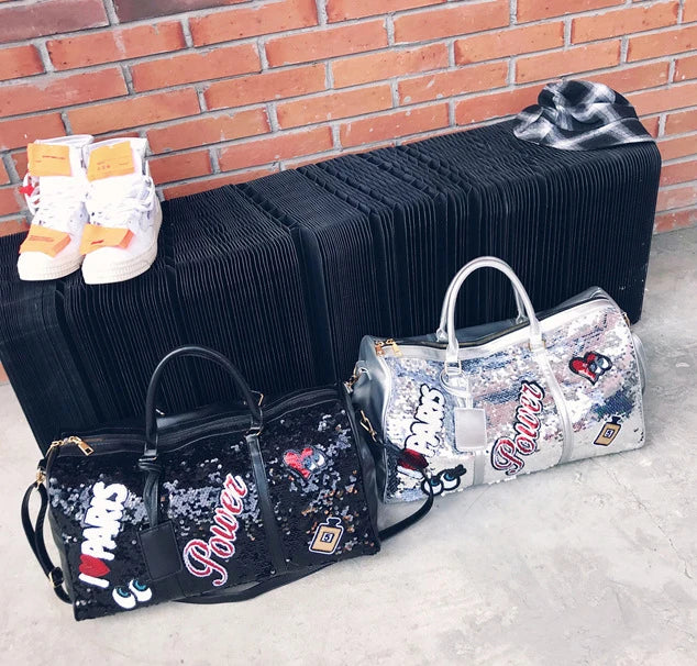 Two handbags with 'Power' branding on a concrete surface with a brick wall background.