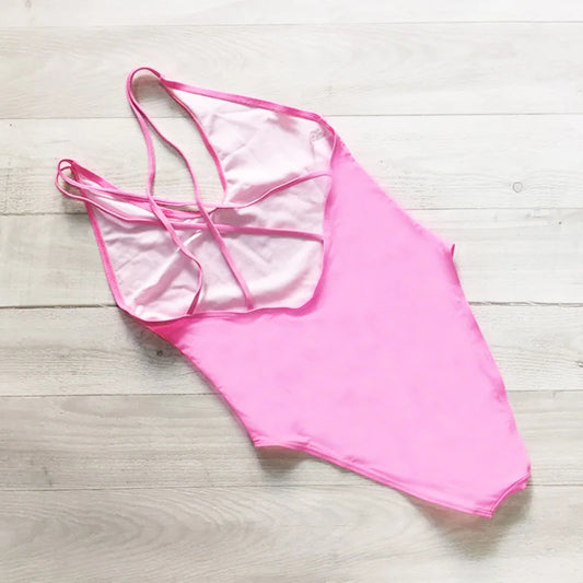 Pink swimsuit on a light wooden surface