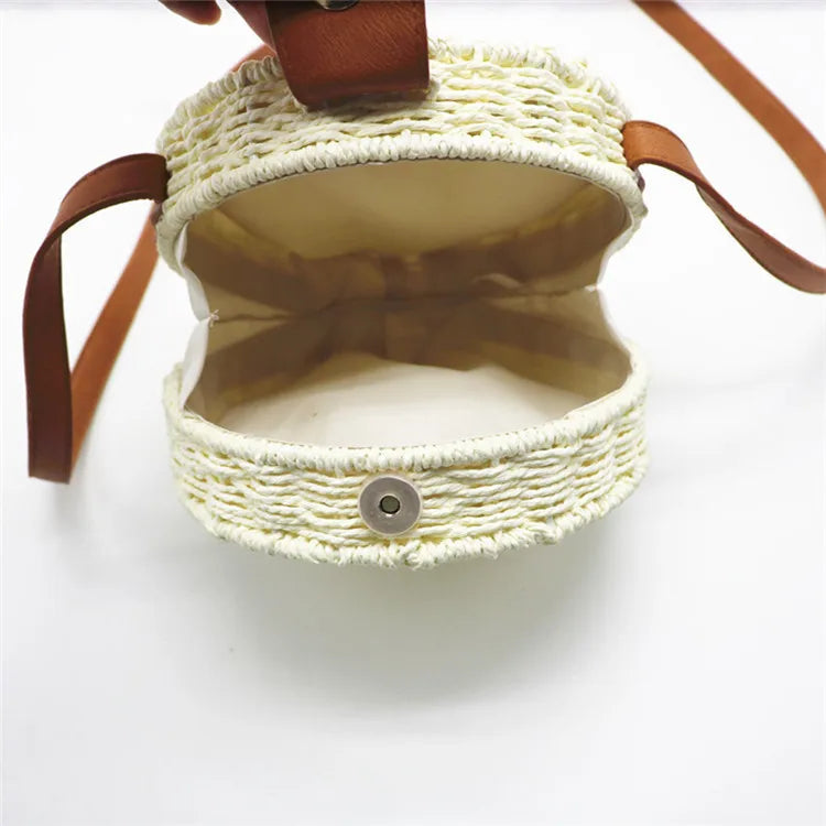 Woven handbag with leather straps on a white background