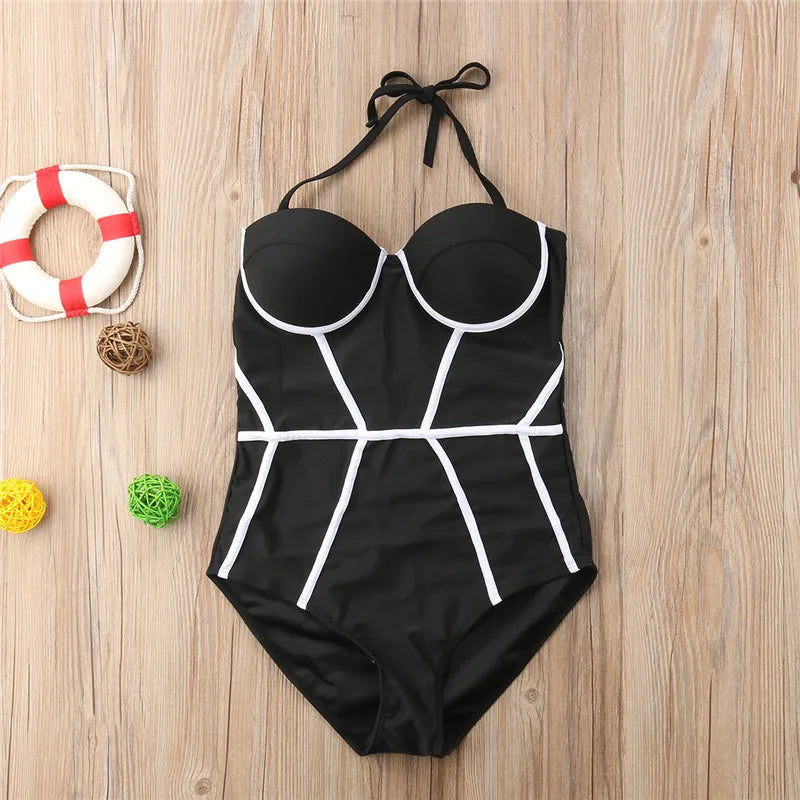 Black swimsuit with white geometric patterns on a wooden surface