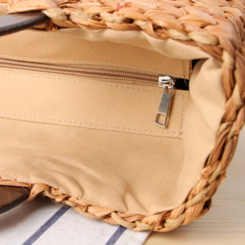 Close-up of a woven bag with a zipper on a striped fabric background